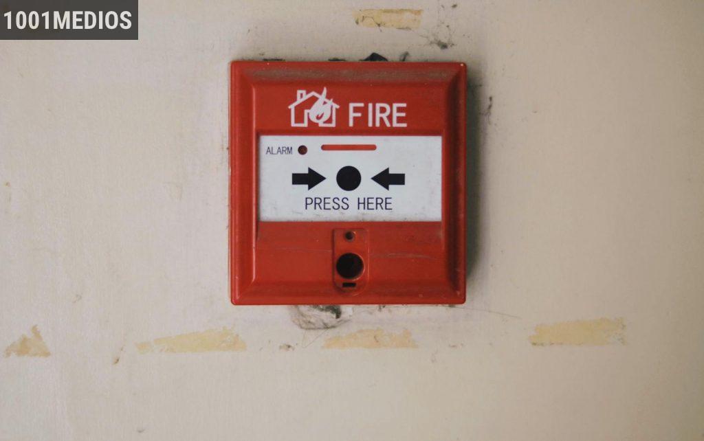 Emergency safety fire detection system box for safety with inscription and push button placed on white wall in light room