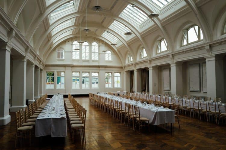 Salón preparado con mesas largas para un evento corporativo