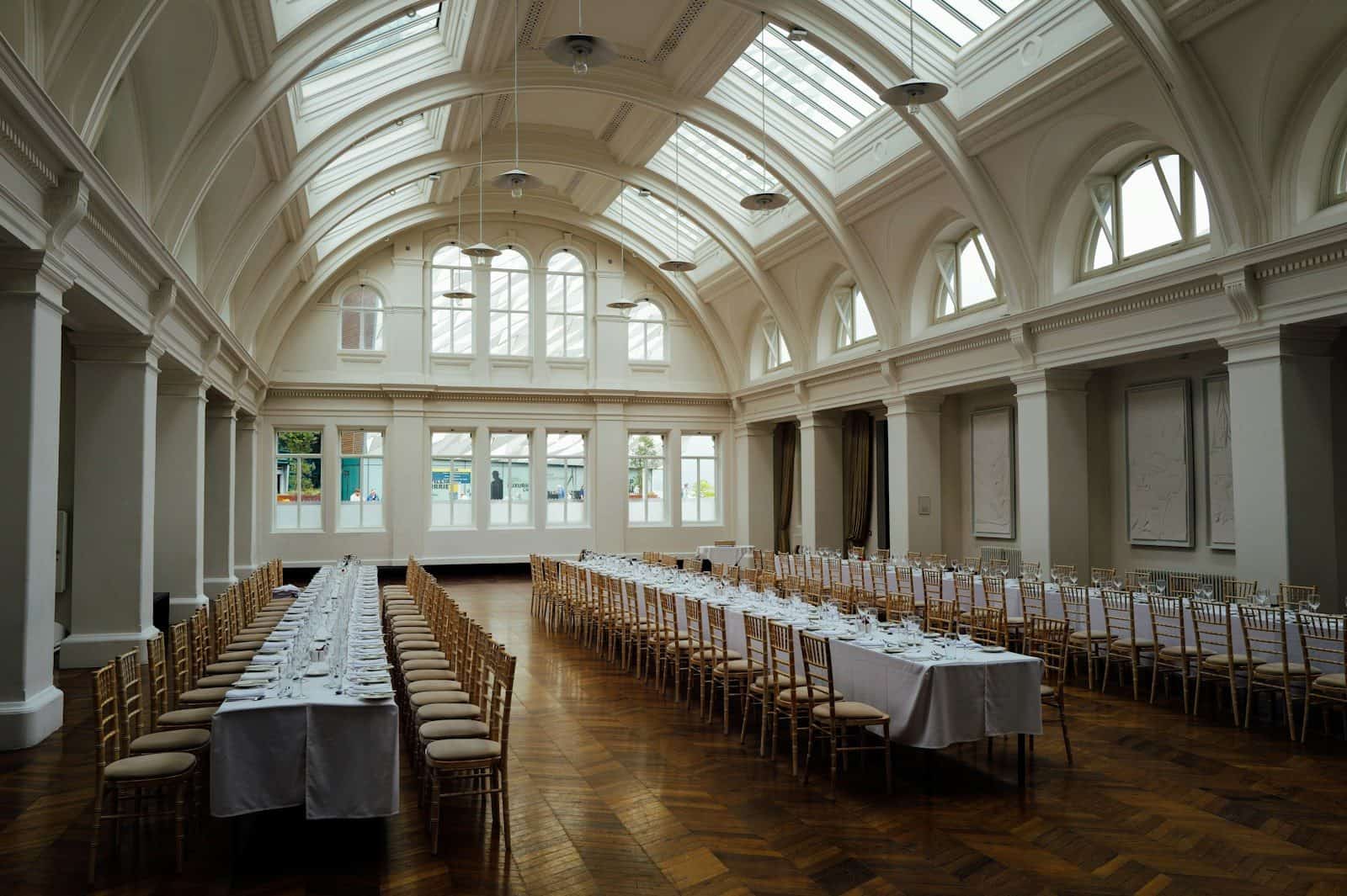Salón preparado con mesas largas para un evento corporativo